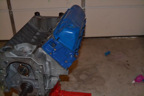 1981 Ford F-250 - Close-up of an engine block with a freshly painted blue valve cover, resting on an engine stand.