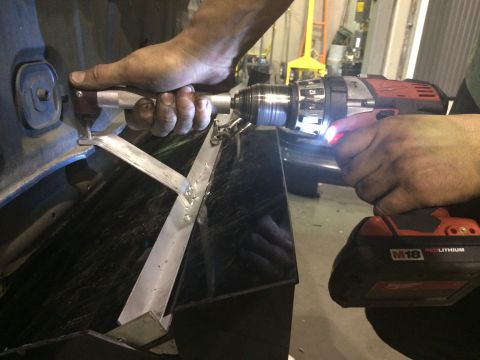 1995 Ford Probe - Hands are shown using a drill to attach a metal bracket to a black car part, with the Supermotors.net logo visible in the lower right corne…
