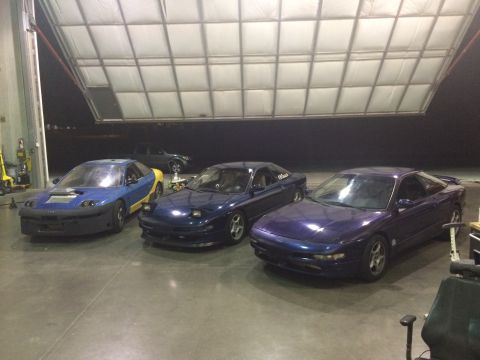1995 Ford Probe - Three Ford Probe models are lined up inside a large garage space.