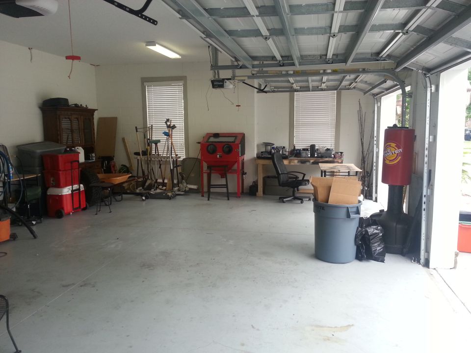 Garage interior with a workbench, tools, storage bins, and a sandblaster
