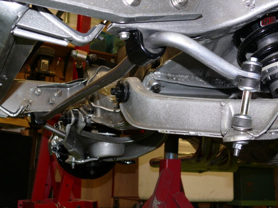 Rear suspension components on a vehicle, with "SUPERMOTORS.NET" watermark