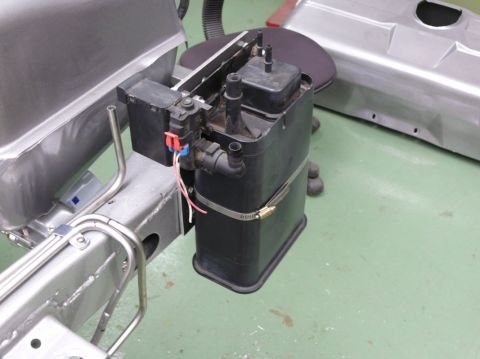 Evaporative emissions canister and fuel lines on a vehicle frame