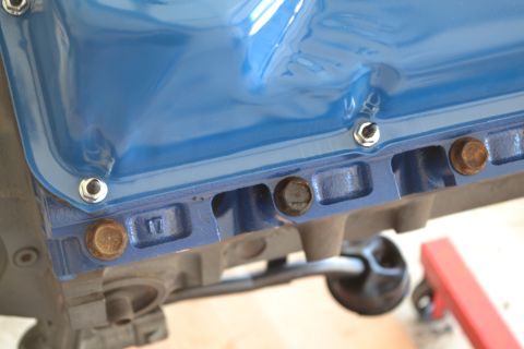 1981 Ford F-250 - Close-up of a blue oil pan attached to an engine block, with visible bolts and a '17' marking.