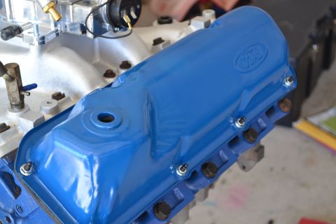 1981 Ford F-250 - A close-up view of a blue Ford valve cover on an engine, with visible bolts and other engine components.