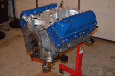 1981 Ford F-250 - Engine assembly with blue valve covers and silver intake manifold on a red engine stand.