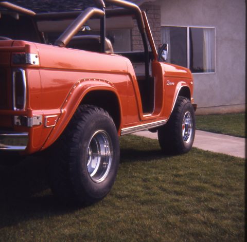 1996 Ford Bronco - This classic Ford Bronco is parked on a grassy lawn in front of a house.