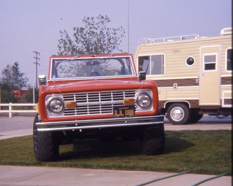 1996 Ford Bronco - This red Ford Bronco is parked next to a travel trailer.