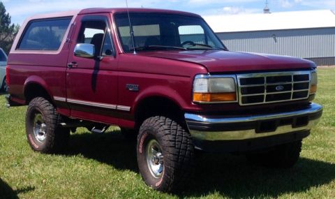 1996 Ford Bronco - This 1996 Ford Bronco features a two-tone paint scheme with a maroon body and a tan removable top.