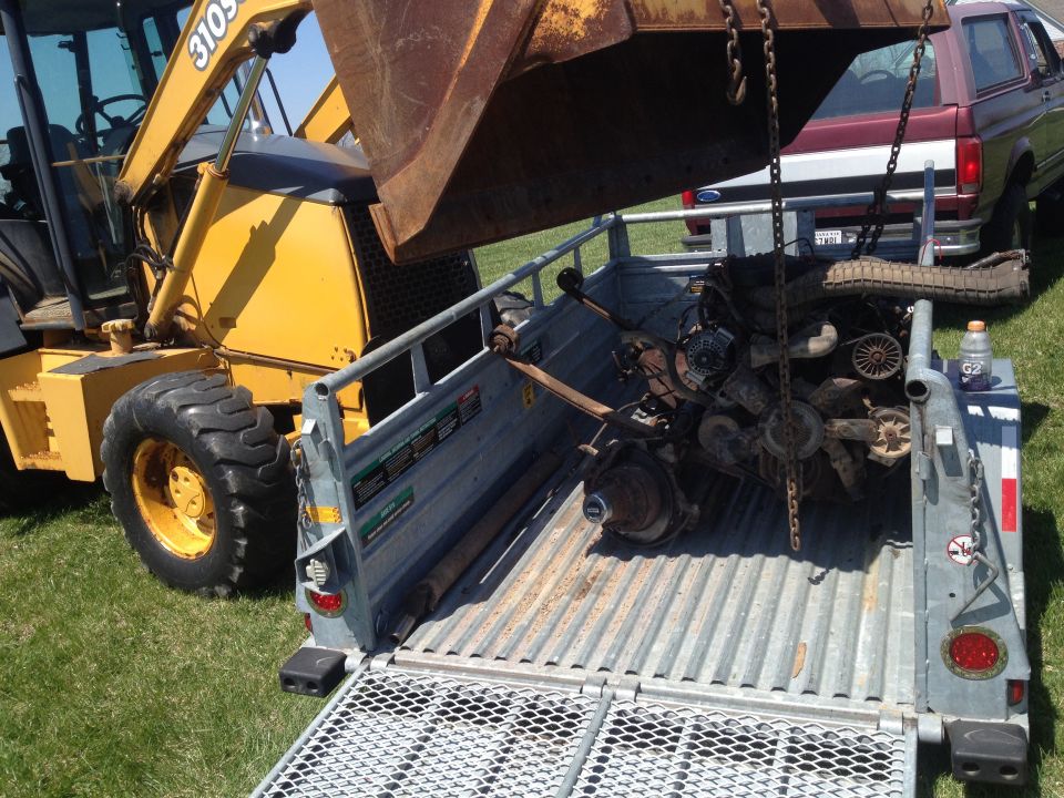 Engine and suspension parts on trailer, 1992 Ford Bronco in background