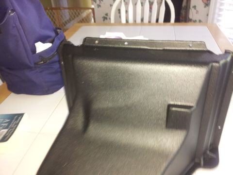 1976 Ford Ranchero - A black plastic automotive part is shown on a table, with a blue bag in the background.