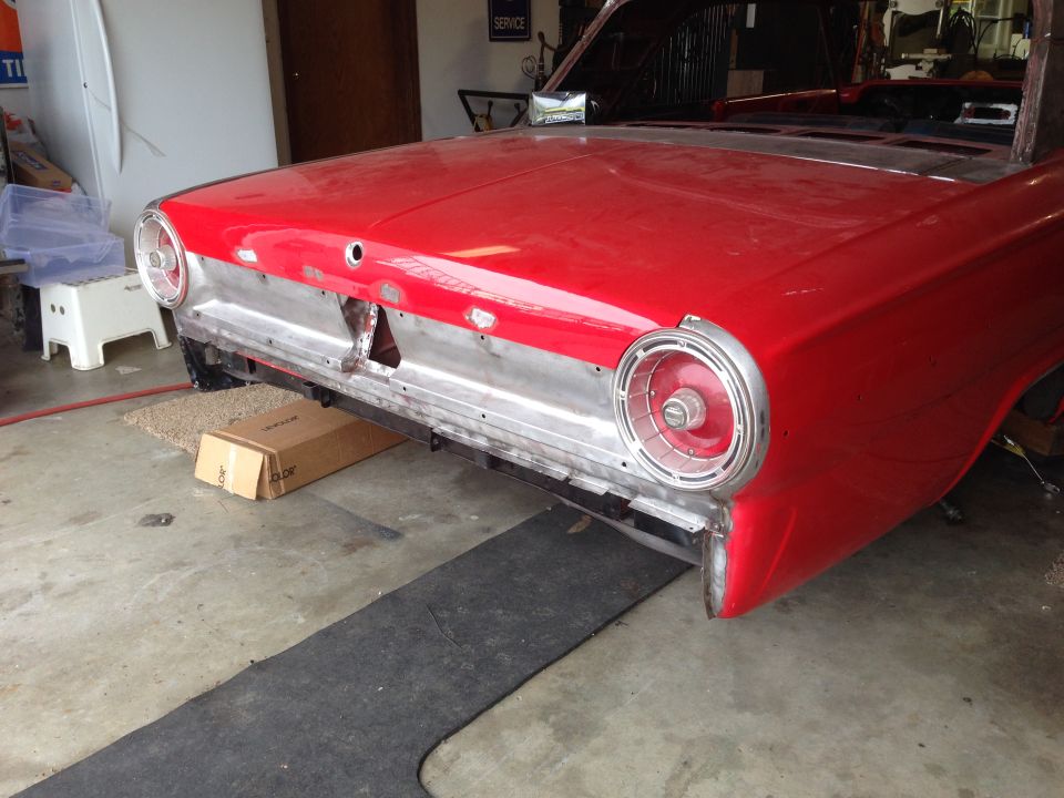 Red 1964 Ford Fairlane rear quarter panel and taillight assembly, undergoing restoration