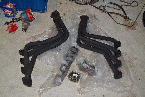 1981 Ford F-250 - Engine exhaust headers and a distributor are laid out on a concrete surface.