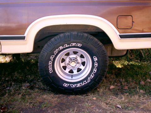 1980 Ford Bronco - Close-up of a vintage Ford Bronco's rear wheel and fender, showing the tire and body details.