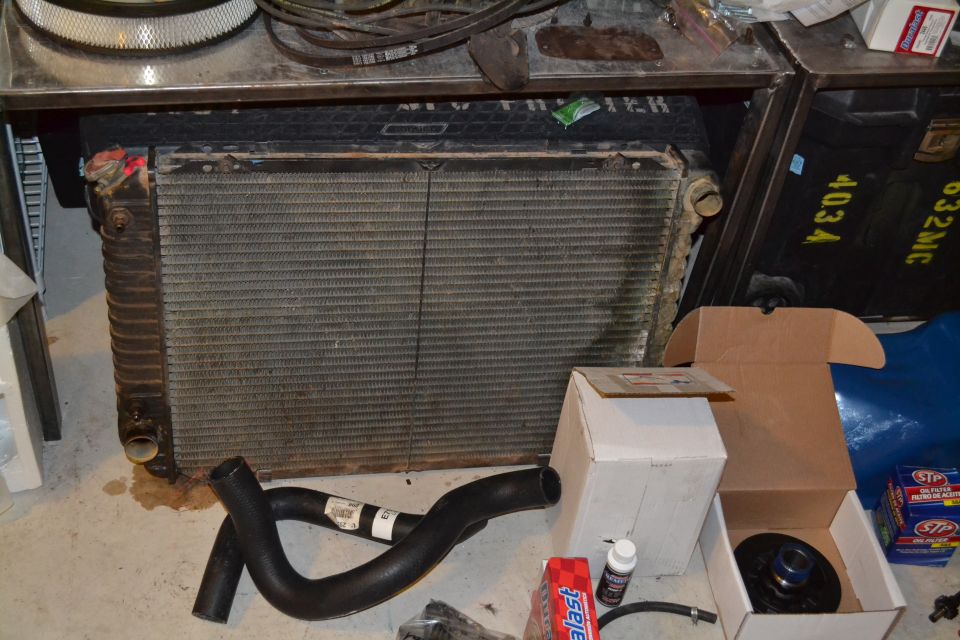 Radiator and hoses on a concrete floor with boxes and air filter in the background