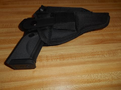 1994 Ford Bronco - A black handgun is secured in a black nylon holster, resting on a wooden surface.