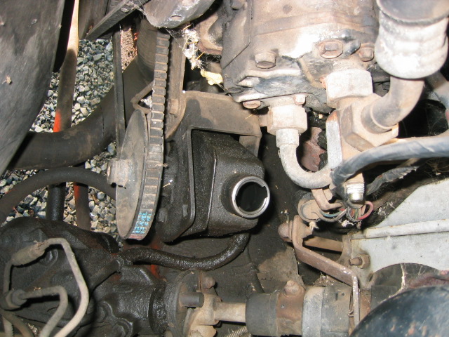 Power steering pump with open filler neck and belt-driven pulley in engine bay