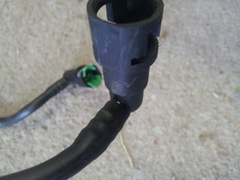 2002 Chrysler 300M - Close-up of a black fuel line connector with a green insert, showing a part of the hose attached.