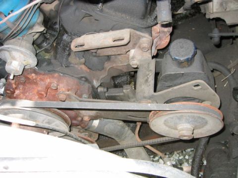 1973 Ford F-100 - Close-up view of engine components including the power steering pump and drive belts.