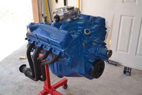 1981 Ford F-250 - A blue Ford V8 engine is mounted on a red engine stand, ready for installation.