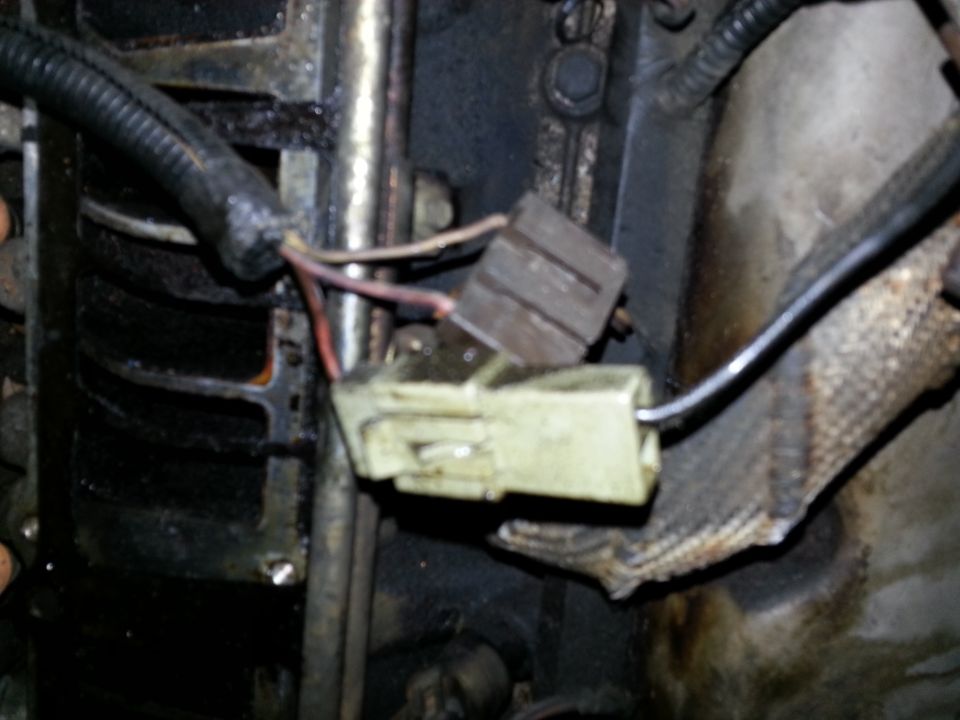 Engine wiring harness connector with frayed wires and a yellow plastic housing