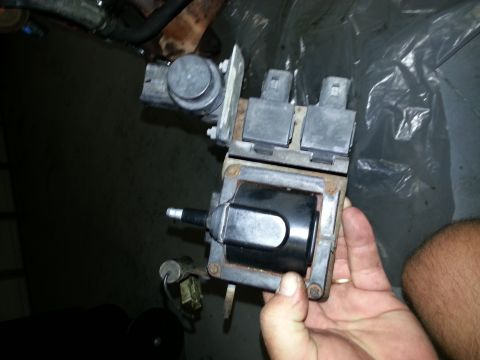 1994 Ford Bronco - Ignition coil pack held in hand, part of a vehicle's engine system.