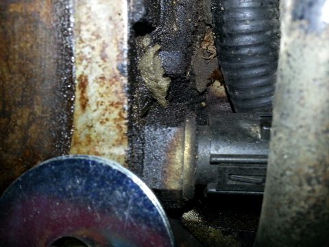 1994 Ford Bronco - Greasy engine component with a washer and electrical connector visible.