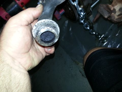 1994 Ford Bronco - A hand holds a dirty exhaust pipe filled with black soot, with mechanical components visible in the background.