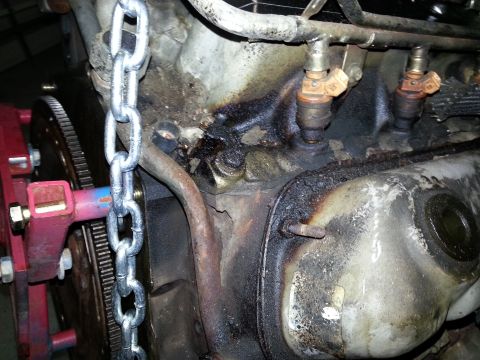 1994 Ford Bronco - Close-up of an engine block showing fuel injectors and a chain hoist attachment.