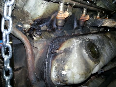 1994 Ford Bronco - This image shows a close-up view of engine fuel injectors, covered in oil and grime.