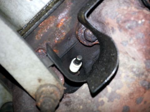 1994 Ford Bronco - This is a close-up view of a spark plug installed in an engine, showing signs of wear and rust.