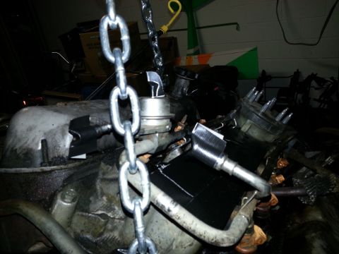 1994 Ford Bronco - Engine components are visible, including a distributor cap and spark plug wires, with chains attached for lifting.