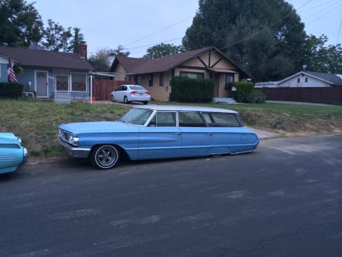1968 Ford Mustang - Customized blue station wagon with a significantly lowered suspension sits parked on a residential street.
