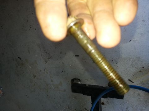 1994 Ford Bronco - Bolt with oil residue, likely from an engine or transmission.