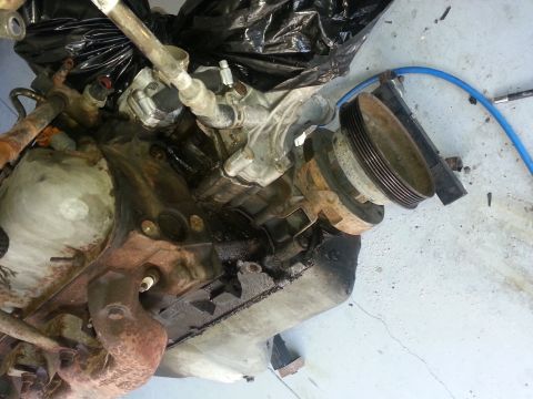 1994 Ford Bronco - Engine part with visible oil and rust, photographed from above.