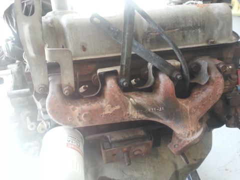 1994 Ford Bronco - This image shows a close-up of an engine's exhaust manifold, with some text visible on the part.