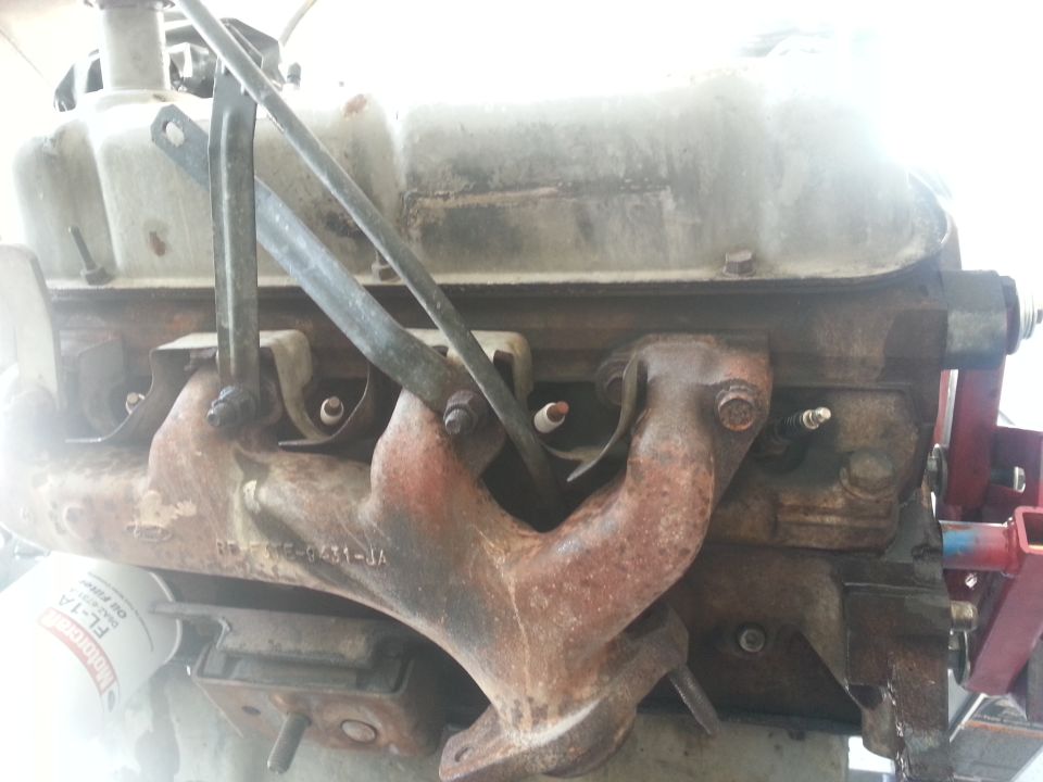 Engine block and exhaust manifold with visible part numbers and a Motorcraft oil filter
