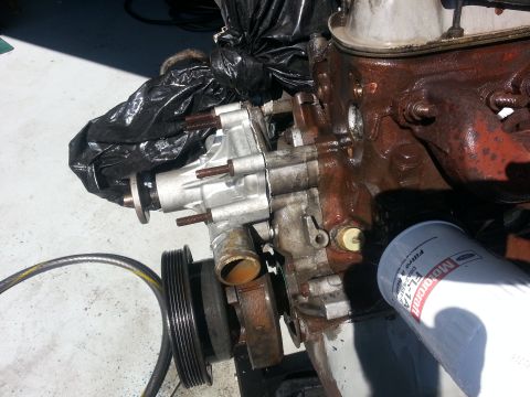 1994 Ford Bronco - Close-up of an engine water pump and oil filter assembly, with a pulley in view.