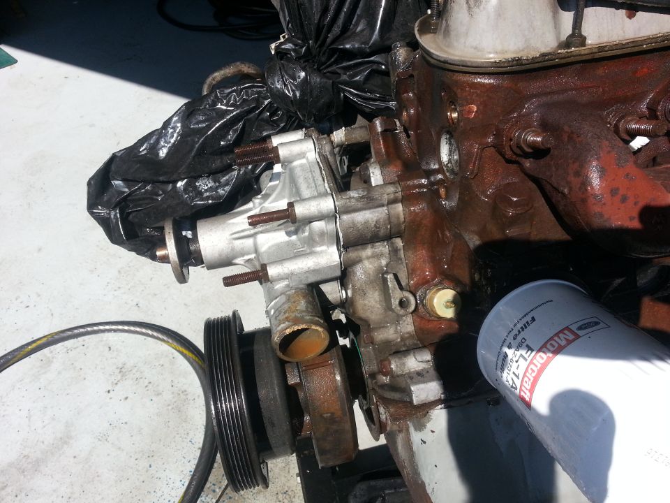 Engine water pump assembly and Motorcraft oil filter. Pulley visible