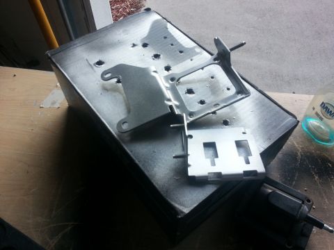 1994 Ford Bronco - Metal parts are laid out on a workbench, possibly for a project or repair.