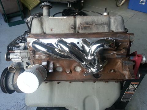 1994 Ford Bronco - Engine block with chrome exhaust headers and an oil filter is shown in a garage setting.