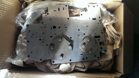 2000 Mercury Grand Marquis - A metal plate with circular indentations and bolts is shown inside a cardboard box.