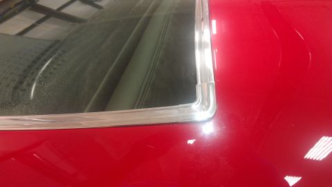 1972 Pontiac Trans Am - Close-up of the rear window trim and interior of a red car, with a Supermotors watermark visible.
