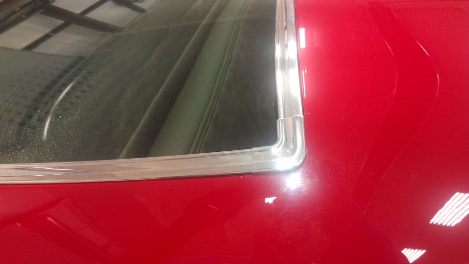 Red car rear window trim and interior detail. Watermark "SUPERMOTORS www.supermotors.net"