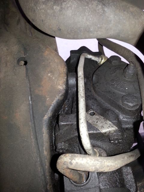 1992 Ford Bronco - Close-up view of a power steering pump with attached metal lines.