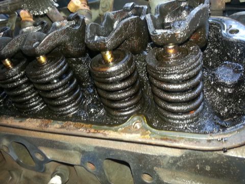 1994 Ford Bronco - Close-up of an engine's valve train, heavily coated in black sludge.