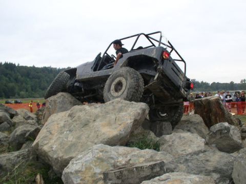1982 Ford Bronco - A driver navigates a challenging rocky terrain in a modified off-road vehicle.