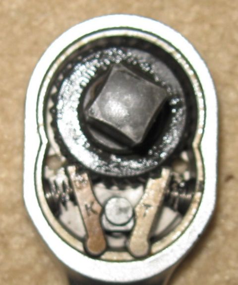 2000 Ford Crown Victoria - The internal workings of a ratchet tool show gears and pawls, with visible wear and grime.