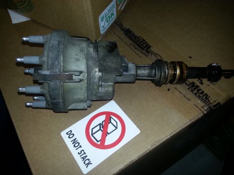 1994 Ford Bronco - A car distributor part is shown resting on a box with shipping labels and warnings.