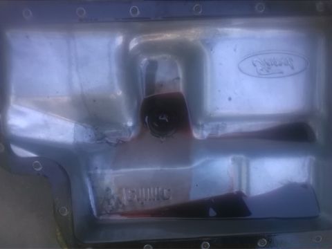 1992 Ford Bronco - Close-up of a Ford oil pan, showing dark fluid and the embossed Ford logo.