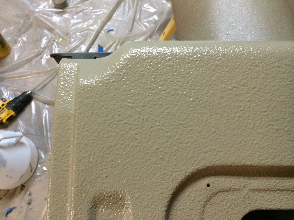 Tan textured surface, possibly a tailgate, with a drill and bucket in the background. Supermotors.net logo visible